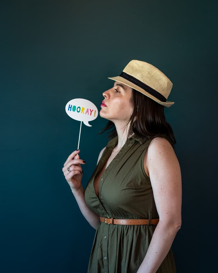 A woman posing with a hat.